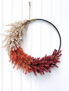 a wreath with dried flowers hanging on the wall