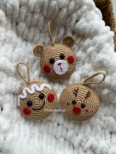 three crocheted christmas ornaments are sitting on a white blanket with red nose noses