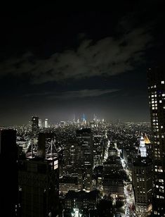 an aerial view of the city at night with skyscrapers lit up in the distance