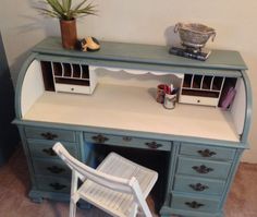 an old desk with a chair and potted plant on top, next to it