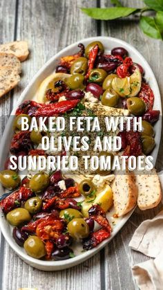 baked feta with olives and sundried tomatoes on a white platter