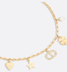 The Petit CD Lucky Charms bracelet is a delicate creation steeped in the symbols so dear to Mr. Dior. Crafted in gold-finish metal, it is embellished with a white resin pearl, as well as star, heart, clover and CD signature charms adorned with silver-tone reflective crystals. The refined bracelet is ideal for pairing with other creations from the Petit CD Lucky Charms line.. Diamond Charm Bracelet, Christian Dior Jewelry, Dior Bracelet, Resin Pearl, Lucky Charm Bracelet, Charms Bracelet, Dior Jewelry, Gold Charm Bracelet, Lucky Charms