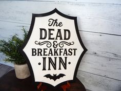 a sign that says the dead and breakfast inn on it next to a potted plant