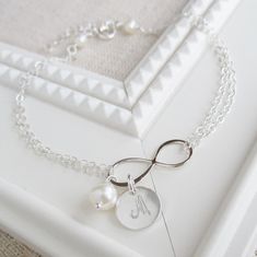 A polished infinity symbol is centered on a double strand of sterling silver chain & adorned with a freshwater pearl and the initial of your choice. Bracelet adjusts from 7 to 8 inches. 3 font choices available! Silver bracelet shown is solid sterling silver. Gold bracelet features 14K gold filled findings with a polished solid bronze infinity charm. >>To enter to my shop<< http://www.kgarnerdesigns.etsy.com Please contact me PRIOR TO PURCHASE if you are ordering on a deadline. I Silver Initial Bracelet, Initial Bracelet Silver, Silver Infinity Bracelets, Mom Jewelry Personalized, Mothers Bracelet, Infinity Charm, Jewelry Personalized, Freshwater Pearl Bracelet, Mom Jewelry