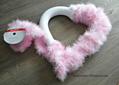 a pink furry animal headband laying on top of a wooden floor next to a tag