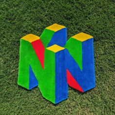 a colorful object laying in the grass on top of it's side with one block missing