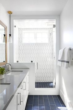 a bathroom with blue and white tile floors and walls, along with a walk in shower