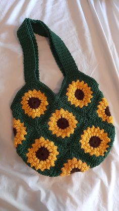 a green crocheted bag with sunflowers on it