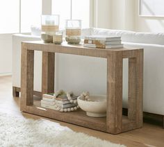 a living room with a couch, table and books on the shelf next to it