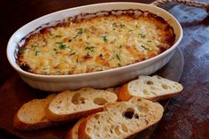 a casserole dish with bread slices on the side