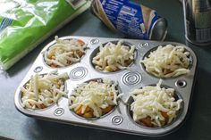 a muffin tin filled with cupcakes covered in cheese and carrots next to a can of soda