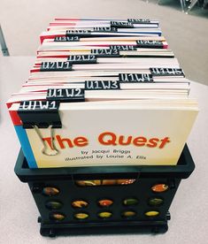 a stack of books sitting on top of a table next to each other with the words the quest written on them