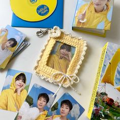 a table topped with photos and pictures of people in yellow clothes next to a cd