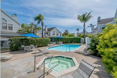 an outdoor swimming pool with lounge chairs and umbrellas