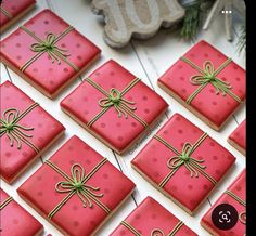 decorated cookies with bows and ribbons are displayed on a white table next to a christmas ornament