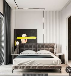 a modern bedroom with white walls and black furniture, including a large painting on the wall