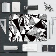 a black and white pattern on a mouse pad next to other office supplies including pens, scissors, paper clips and markers