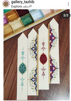 some very pretty designs on some kind of bookmarks with paintbrushes in the background