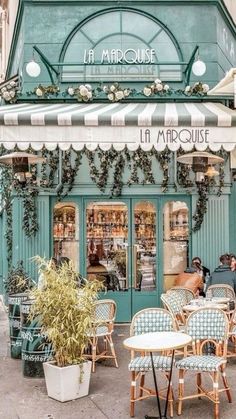 an outdoor cafe with blue and white awnings on the side of the street