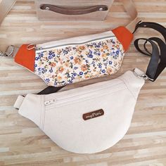 two purses sitting on the floor next to each other, one with an orange lining