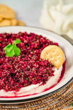 a white plate topped with food next to crackers