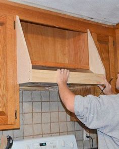 a man is working on cabinets in the kitchen