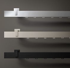 three metal shelfs with different shapes and sizes hanging on the wall in a room