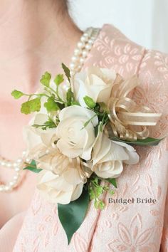 a bridal bouquet with white flowers and greenery on the bride's dress