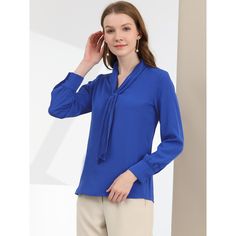 It features a classic design with a tie and long sleeves with button cuffs, creating a fitted silhouette, especially for work or office. Designed in a fluid, flowing fabric that drapes beautifully around the body. Offering effortless style, the blouse falls beautifully on the body and features a subtly pleated design to add to the delicate nature. A tie front design creates a feminine finish on this shirt, an everyday staple for the office. Style it with your favorite jeans and heels for a styli Blue Long Sleeve Blouse For Formal Occasions, Blue Long Sleeve Formal Blouse, Fall Business Blouse With Long Sleeves, Fall Workwear Top, Solid Color Long Sleeve Formal Blouse, Solid Color Tie Neck Office Blouse, Solid Tie Neck Blouse For Office, Casual Tie Neck Blouse For Office, Formal Long Sleeve Solid Blouse