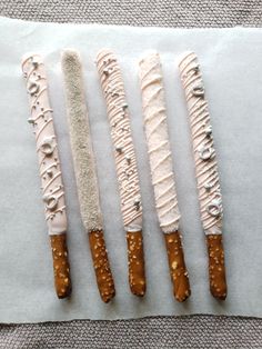 four different types of food on top of white paper with brown and white icing