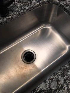 a stainless steel sink in a granite counter top