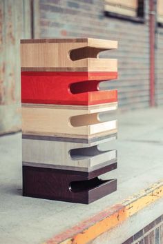 a stack of wooden blocks sitting on top of a cement floor next to a brick wall