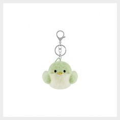 a keychain with a small green stuffed animal hanging from it's side