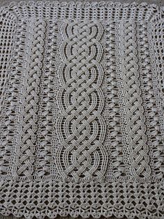 a white crocheted blanket on top of a wooden floor