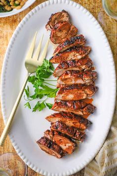 grilled meat on a white plate with garnish