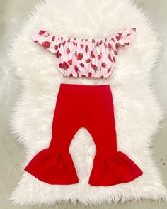 "Beautiful red bell pants and crop top. Perfect for strawberry themed birthdays.  The little bow sizes Newborn-2t comes on nylon, the 3t sizes and up will come on alligator clip  The set is made of ribbed stretchy knit fabric. Runs true to size. I won't recommend sizing up.  Size-inseam of leggings/waist  NB-6\"/13\" 0-3m-7\"/14.5\" 3-6m-8\"/15.5\" 6-9m- 9\"/16\" 9-12m-10.5\"/16.5\" 12-18m-11.5\"/17.25\" 18-24m-13\"/18\" 2-3t-14.5\"/18.5 3-4t-15\"/19\" 4-5y-15.5\"/19.5\" 5-6y-16\"/20\"" Cute Strawberry Print Sets For Spring, Cute Red Sets For Spring, Cute Red Ruffled Bottoms, Fitted Strawberry Print Bottoms For Summer, Pink Fitted Bottoms With Strawberry Print, Fitted Pink Bottoms With Strawberry Print, Playful Red Ruffled Sets, Playful Red Fitted Set, Playful Red Fitted Sets