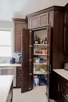 an open pantry door in the middle of a kitchen