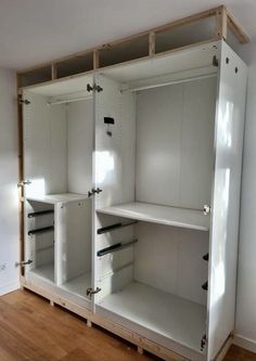 an empty room with white cabinets and wood flooring