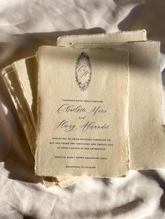 three wedding cards are laying on top of each other in white sheets and linens