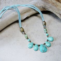 "Rustic southwestern styling in this beaded faux suede aqua cord necklace. Antique brass beads accent tear drop turquoise blue magnesite beads. The focal beaded segment is linked to soft faux suede aqua blue ties that are accented with antique brass beads and links and crimped to a matching lobster claw closure. Length of the necklace is 24\" All of my jewelry items come boxed and lace ribbon tied and tagged for easy gifting. This necklace is ready to ship." Adjustable Beaded Necklace With Teardrop Pendant, Adjustable Teardrop Turquoise Necklace With Natural Stones, Bohemian Turquoise Teardrop Pendant Necklace, Adjustable Bohemian Beaded Necklace With Teardrop Pendant, Bohemian Adjustable Beaded Necklace With Teardrop Pendant, Bohemian Beaded Teardrop Turquoise Necklace, Bohemian Turquoise Necklace With Adjustable Cord, Bohemian Teardrop Beaded Necklaces With Adjustable Fit, Handmade Bohemian Teardrop Turquoise Necklace