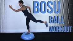 a man in black shirt and leggings standing on blue ball with bosu balance