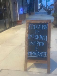 a sign that is on the sidewalk in front of a building saying education is important but beer is important