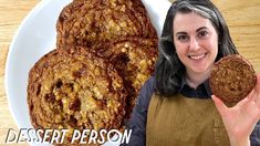 a woman is holding up some cookies on a plate with the words desert person in front of her