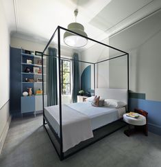 a bedroom with a canopy bed and blue walls