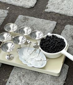 a tray with spoons and blackberries on it