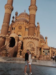 two people standing in front of a large building