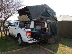 a white truck with a tent attached to it's back