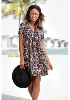 This casual dress with a loose fit and cute print is perfect for a fun day out. Casual Printed V-neck Mini Dress, Trendy Black Mini Dress For Beach, Trendy Black Beach Mini Dress, Casual Printed Mini Dress, Casual Knee-length Mini Dress For Daytime, Casual Mini Length Printed Dress, Trendy Relaxed Fit Beach Dress, Trendy Relaxed Fit Mini Dress For Day Out, Casual V-neck Daytime Dress