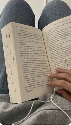 a woman is reading a book while laying down