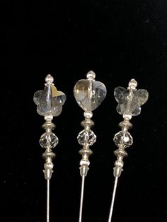 three crystal heart shaped candlesticks on a black background